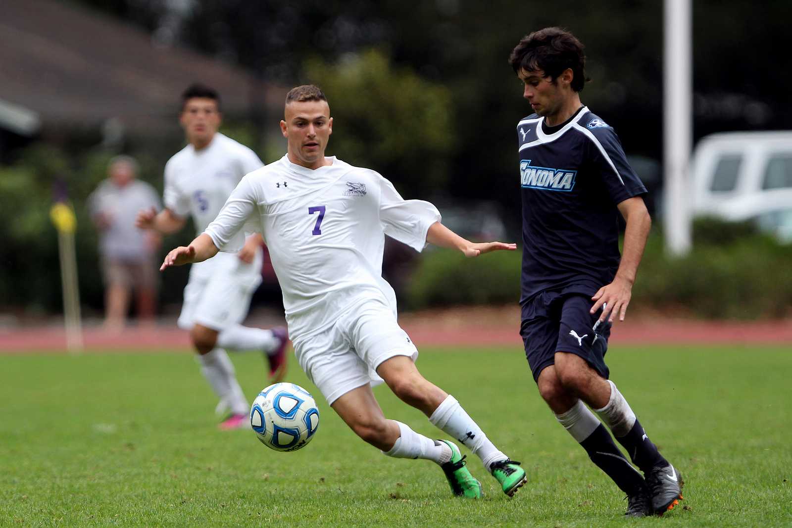 Cole Dimond (7) (left) kicks the ball past Sean Callahan(8) during a game between the SF State Gators and the Sonoma State University Seawolves at Cox Stadium on Sept.13, 2013. The Gators lost in a hard fought battle against the Seawolves, losing 0-1. Photo by Gavin McIntyre / Xpress