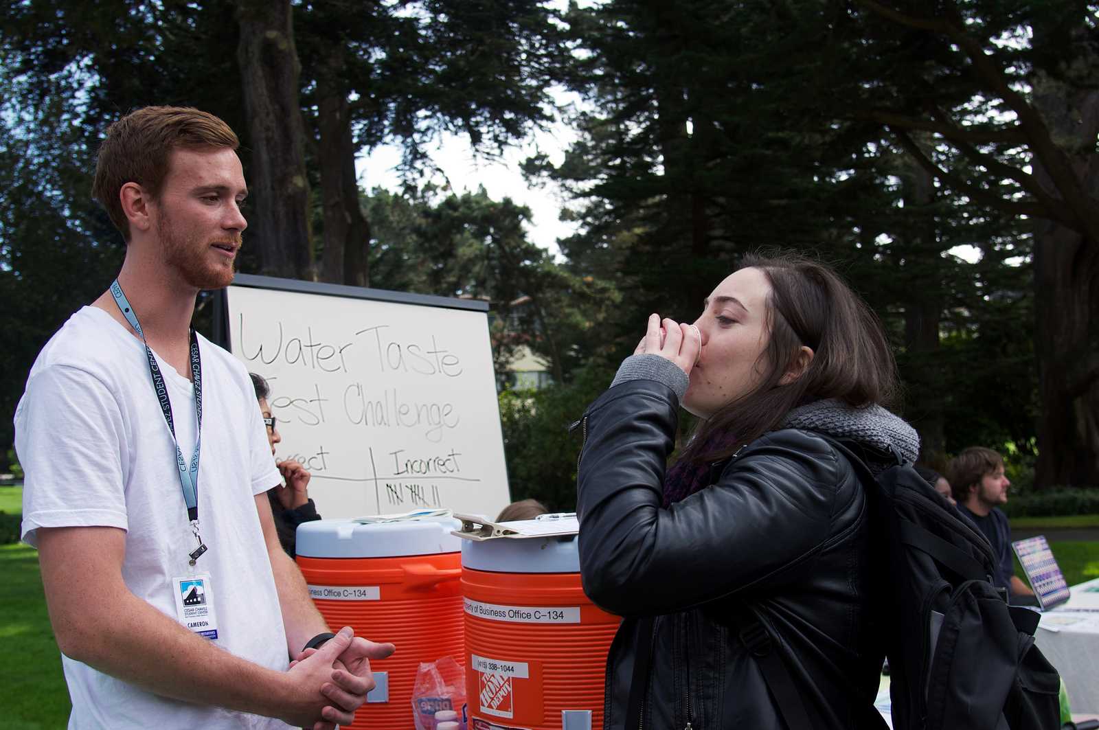 Cameron Bingley watches as Daisy Gerstein takes a water taste test challenge during the sustainability fair in the quad at SF State on Wednesday 23, 2013. Photo by Kate O'Neal / Xpress