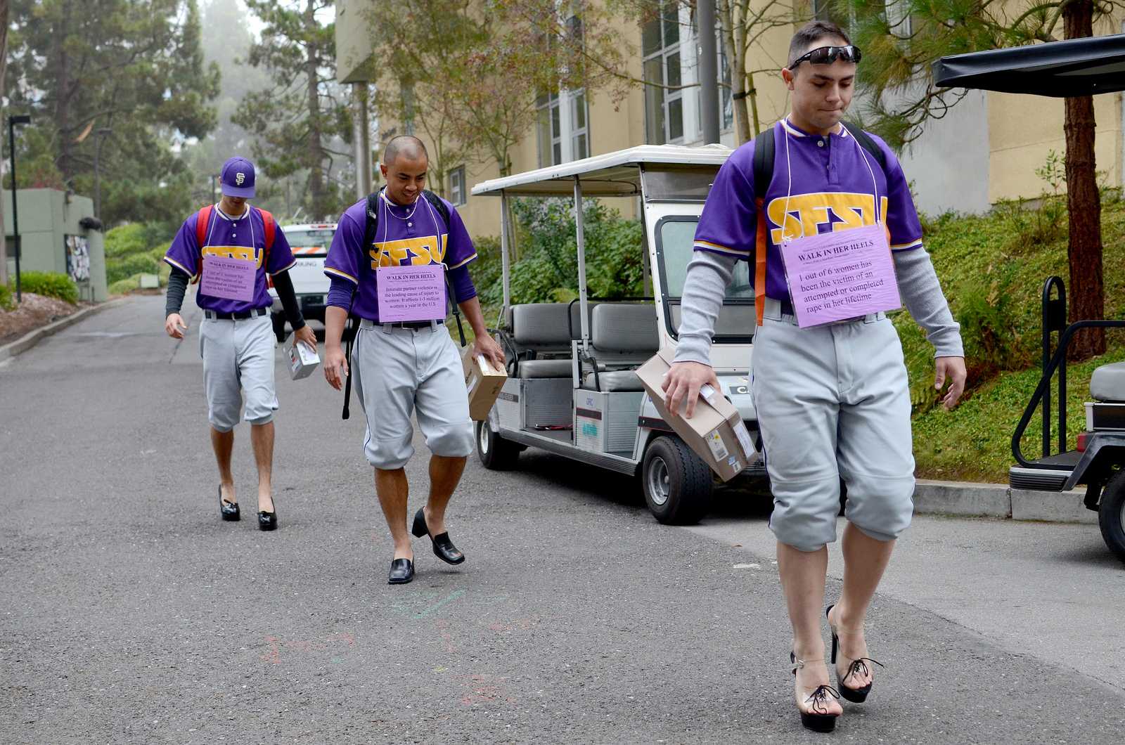 Jack Veronin (left), Peter Reyes (middle) and Carter Loud (right), members of the SF State baseball team, walk in heels for The SAFE Place and Men Can Stop Violence event titled: Walk in Her Heels. This event is a men’s walk to stop rape, sexual assault, and gender violence. Men volunteers sign up, pick up heels and go about their normal days wearing these shoes and collecting donations with a shoe box until noon where the men come together in Malcolm X Plaza at SF State on Tuesday, October 22 to share their experience, if they so choose. Photo by Virginia Tieman / Xpress