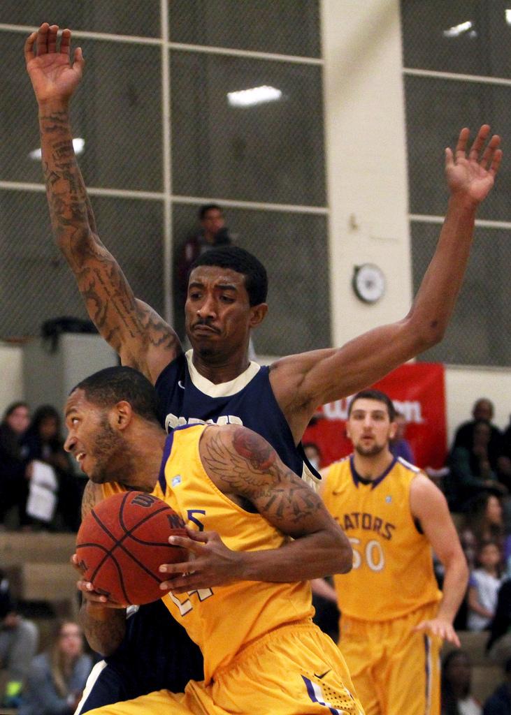 SF State's Brandon Tatum(24) runs into Cal State Monterey Bay's Kris Gallop (15) as he takes the ball to the hoop during a home game against the Otters Saturday, March 1. The Gators won the game 66 to 47. Photo by Gavin McIntyre / Xpress